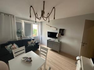 a living room with a couch and a table with chairs at Gdańska Marina- Śródmieście in Gdańsk