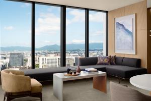 a living room with a couch and a table and windows at The Ritz-Carlton Fukuoka in Fukuoka