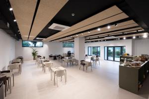 a dining room with tables and chairs and windows at Hotel H4 Cangas 3 Superior in Cangas de Morrazo