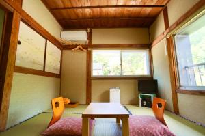 a small room with a table and chairs and a window at Takaosou in Yufuin