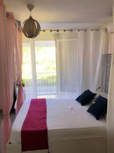 um quarto com uma cama grande e uma janela em Hôtel Le Soleil Couchant em Saint-Pierre