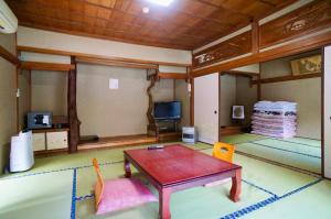 a living room with a table and two chairs at Takaosou in Yufuin