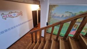 una escalera en una casa con una pintura en la pared en Hanul Moara cu Noroc en Ineu