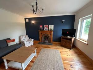 a living room with a couch and a fireplace at An Teach Bábóige - The Doll house - Kildare in Kildare