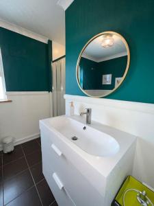 a bathroom with a white sink and a mirror at An Teach Bábóige - The Doll house - Kildare in Kildare