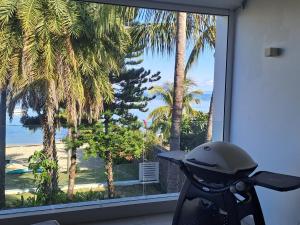 塔馬蘭的住宿－CAPLAGE -Beach Front Luxury Apartment at Searock，停在棕榈树窗户前的摩托车