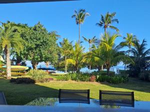 a view of a resort with palm trees and a pool at CAPLAGE - BEACHFRONT GROUND FLOOR APARTMENT in TAMARIN in Tamarin