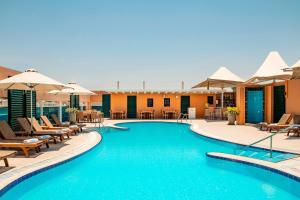 a swimming pool with chairs and umbrellas on a hotel at Four Points by Sheraton Bur Dubai in Dubai