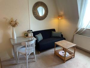 a living room with a blue couch and a table at Hotel Des Falaises in Villers-sur-Mer