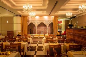 a dining room with tables and chairs and chandeliers at Four Points by Sheraton Bur Dubai in Dubai