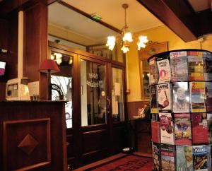 a restaurant with a refrigerator covered in magazines at Hôtel Verlaine in Paris