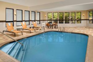 a pool in a hotel room with chairs and a table at Courtyard by Marriott Lufkin in Lufkin