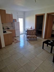 a kitchen with a table and a chair in a room at Πλήρως εξοπλισμένο διαμέρισμα. in Nea Moudania