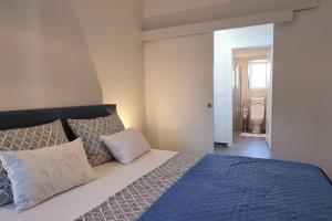 sypialnia z łóżkiem z niebieską pościelą i poduszkami w obiekcie *NEW* Casa Fila *NEW* w mieście Funtana