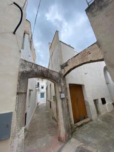 un callejón en un edificio antiguo con un arco en Le volte di una volta, en Tuglie