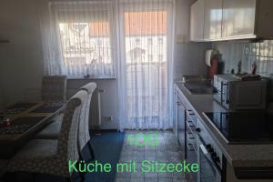 cocina con mesa y sillas y cocina con microondas en Semi-Detached House on 2 Floors, en Giengen an der Brenz