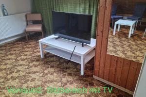 TV en una mesa blanca en la sala de estar en Semi-Detached House on 2 Floors, en Giengen an der Brenz