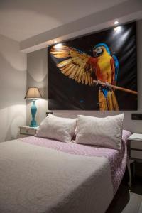 1 dormitorio con una pintura de un loro en la pared en Apartamento Ventanal en Ateca