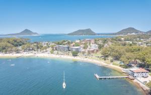 una vista aérea de una playa con un barco en el agua en Bay Parklands 27 2 Gowrie Ave pool tennis court spa and views, en Nelson Bay