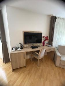 einen Schreibtisch mit einem TV im Wohnzimmer in der Unterkunft Hotel Sonne in Weingarten