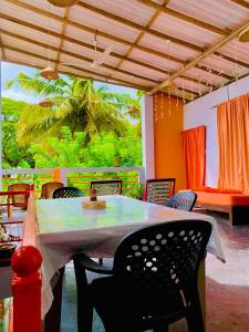 a dining room with a table and chairs and a window at The Orange House Weligama in Matara