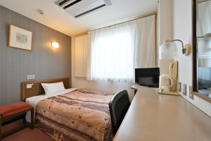 una camera d'albergo con letto e scrivania di Wakayama Daiichi Fuji Hotel a Wakayama