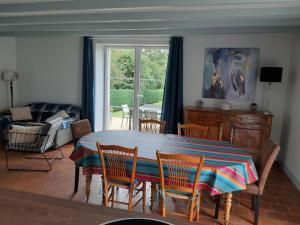 a dining room with a table and chairs and a window at Le Pavillon du Manoir de Conjon in Crouay