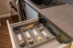 a drawer in a kitchen with silver utensils at Calea Floreasca 77 Aparthotel 1 in Bucharest