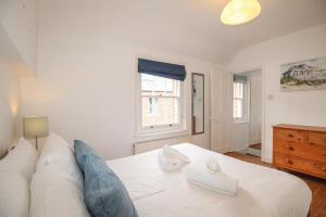 une chambre avec un lit blanc et une fenêtre dans l'établissement Pixie Cottage, à Weymouth