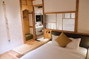 a bedroom with a bed and a large window at Spring12 House in Chiayi City