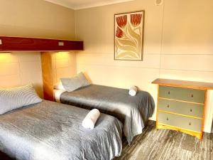 a room with two beds and a dresser in it at Te Anau Lakefront Backpackers in Te Anau +37 photos