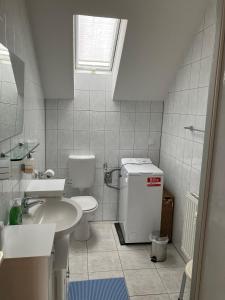 a white bathroom with a sink and a toilet at Ferienwohnung Rhönperle Dermbach in Dermbach