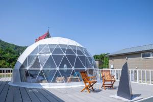 a glass igloo on a deck with two chairs at GLAMP VILLAGE SETOUCHI-SHIMANAMI in Onomichi +15 photos