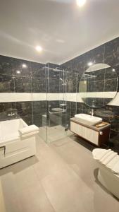 a bathroom with a tub and a sink and a shower at Solo Grand City in Lawean