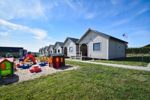 una fila de casas con parque infantil en un patio en Domki Róża Bobolin en Bobolin