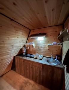 a bathroom with a sink in a wooden cabin at Fairytale Aframe House in Quba