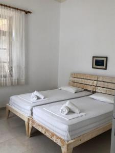 - une chambre avec un grand lit et des draps blancs dans l'établissement Michael&Marika's Traditional House, à Limenaria
