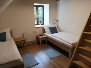 a small room with two beds and a window at Na jelení stezce in Chřibská