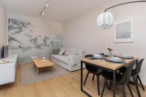 a living room with a table and a couch at Bright & Stylish Apartment with Balcony 1,5 km to Gdańsk Main City by Renters in Gdańsk