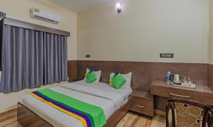 a bedroom with a bed and a desk and a bed sidx sidx sidx at Treebo Trend Pranav Park in Vellore