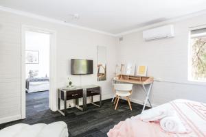 Habitación blanca con escritorio y cama en Central location 2 bdrm free parking and WiFi, en Perth