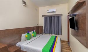 Habitación de hotel con cama y TV en Treebo Trend Pranav Park en Vellore