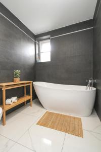 a bathroom with a white tub and a black wall at Apartmán Vita Deluxe in Trenčín