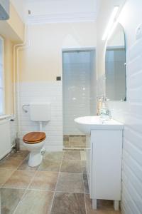 Baño blanco con aseo y lavamanos en Carlone House, en Eger