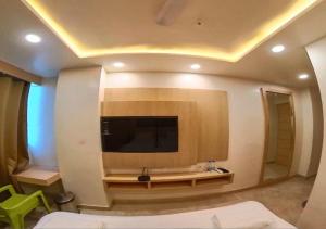 a living room with a tv on a wall at Hotel Prago by Green Deer Varanasi in Varanasi