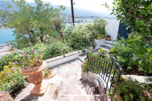 a set of stairs with a bench and flowers at Traditional House under the Clock Tower with Sweet View in Poros