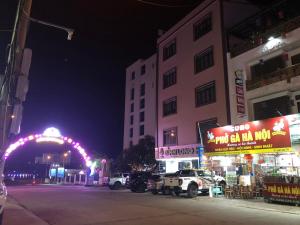 a city street with cars parked in front of buildings at night at Bình Long II Hotel in Lai Châu