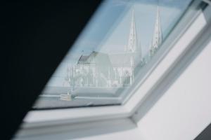 Una ventana con vistas a una iglesia. en Coeur de ville #H2- Central & Cosy - Logement partagé - Chambre privée, en Cholet