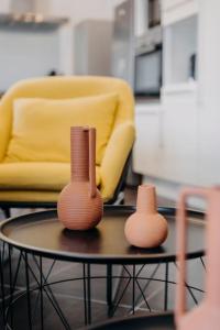 two vases sitting on a table in front of a chair at Coeur de ville #H3 - WIFI et NETFLIX - Lave linge - Logement partagé - Chambre privée in Cholet