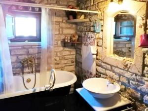 a stone bathroom with a tub and a sink at Alexana - Traditional House in Káto Figália